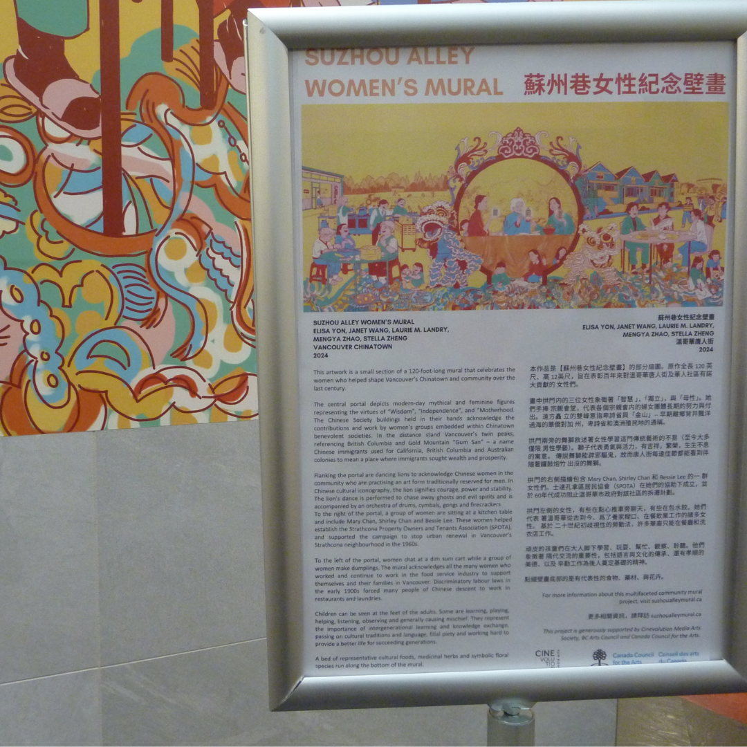 A standing sign at the base of the mural provides information about the mural. The sign is bilingual, with English on the left, and Chinese on the right.